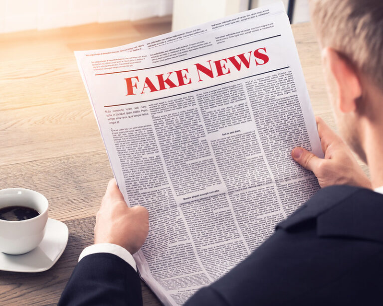 Persoon leest krant getiteld Fake News