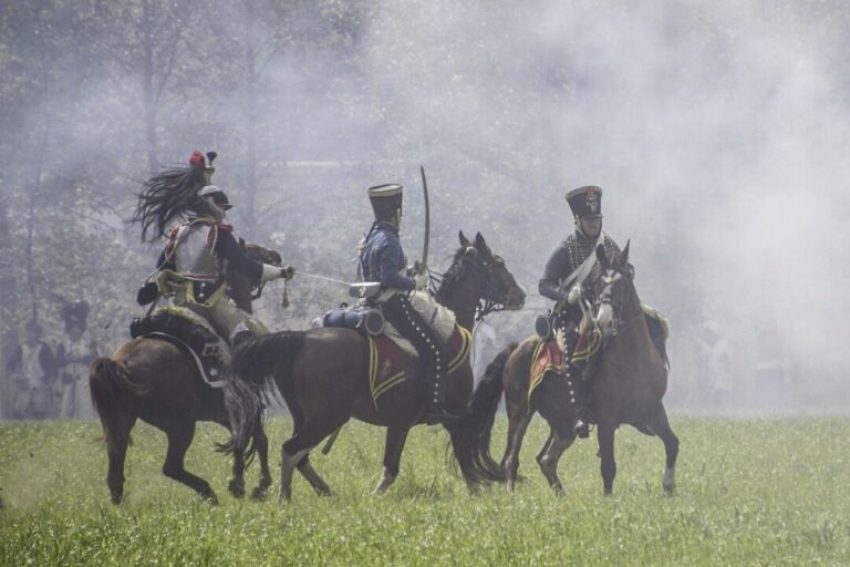 Ruiters met sabels in een slagveld gevuld met rook.