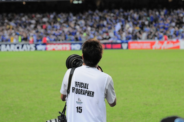 Een fotograaf die een foto maakt bij een voetbalwedstrijd.